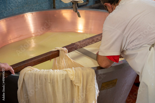 Process of making wheels of parmigiano-reggiano parmesan cheese on small cheese farm in Parma, Italy, copper-lined vats with curd