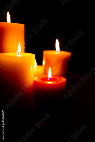 Burning red candles on black background
