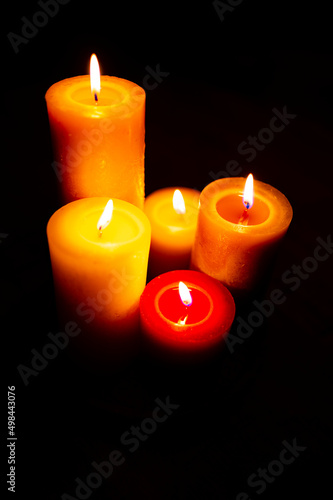 Burning red candles on black background