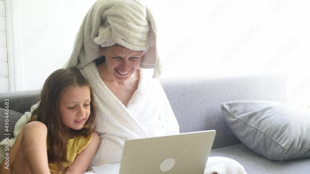 Mother and kid girl using laptop at home, looking at screen choosing goods online. Happy mom talking to child daughter showing new computer applications, watching video, internet shopping together Mother and kid girl using laptop at home, looking at screen choosing goods online. Happy mom talking to child daughter showing new computer applications, watching video, internet shopping together