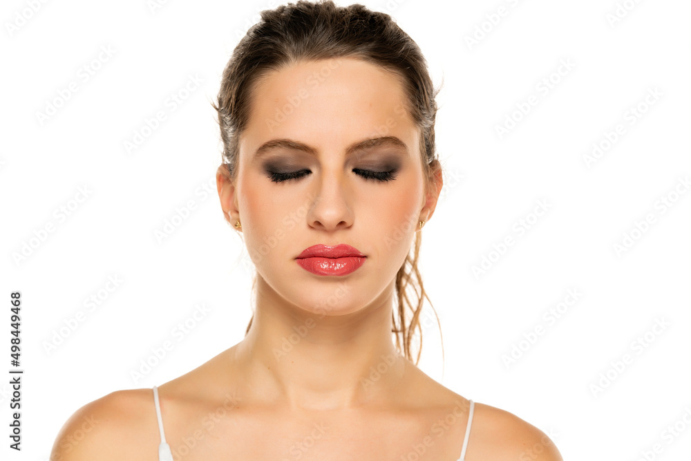 Beautiful serious woman with make up and closed eyes on a white background Beautiful serious woman with make up and closed eyes on a white background
