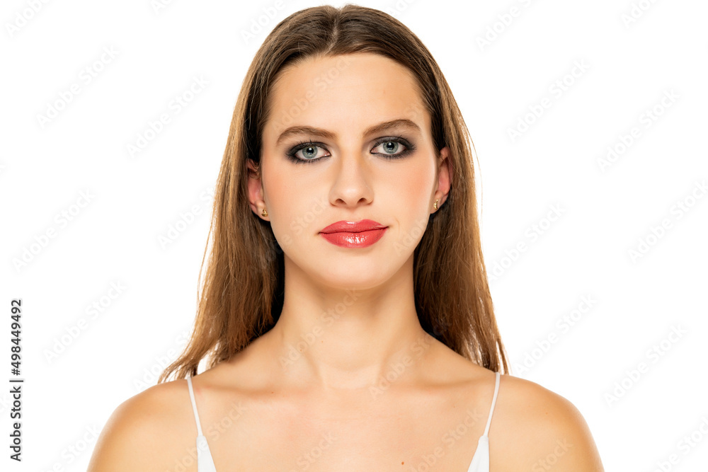Beautiful serious woman with make up and long hair on a white background Beautiful serious woman with make up and long hair on a white background