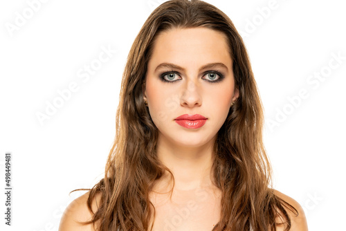 Beautiful serious woman with make up and wavy hair on a white background