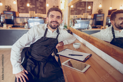 Cheerful bearded man working in coffee shop