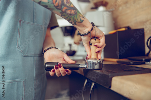 Young woman hands making coffee in cafe