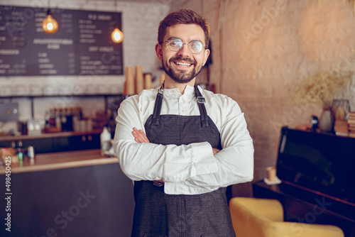 Canvas Cheerful male barista in apron standing in cafe