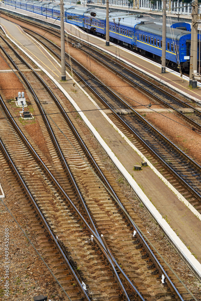 Fototapeta premium railway station infrastructure - rails, platform and passenger railcars