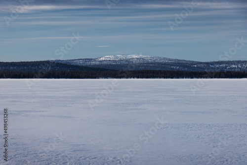 snow frozen lake and mountain in the distance in beautiful north finish lapland 