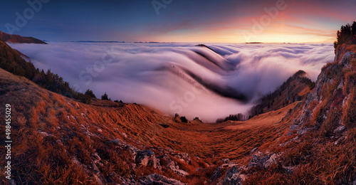 Colorfull sunset behind Mountain peak landscape above clouds - panorama