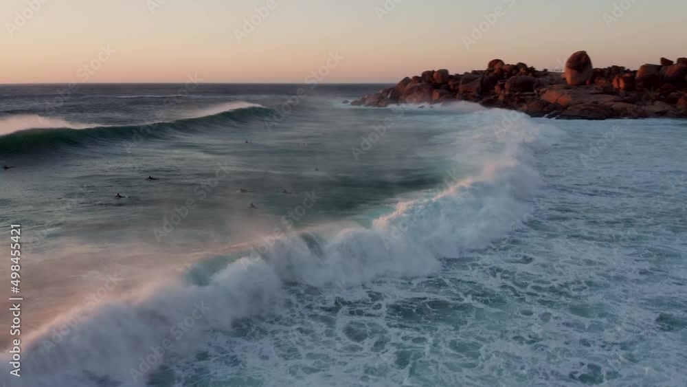 Surfers Riding Waves At Sunset In Llandudno, Cape Town, South Africa - aerial drone shot Surfers Riding Waves At Sunset In Llandudno, Cape Town, South Africa - aerial drone shot