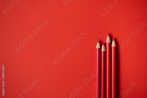 Rote Buntstifte auf rotem Hintergrund. Freiraum für Text