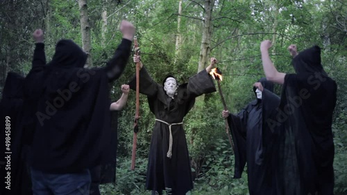 A circle of evil hooded druids in a cult performing a sorcery ritual photo