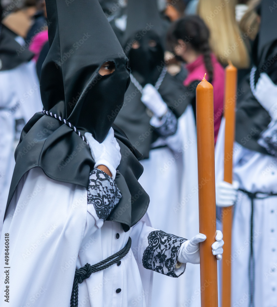 Semana santa Valladolid, hermandad del santísimo Cristo de Medinaceli con gran cirio y capirote negro - obrazy, fototapety, plakaty 