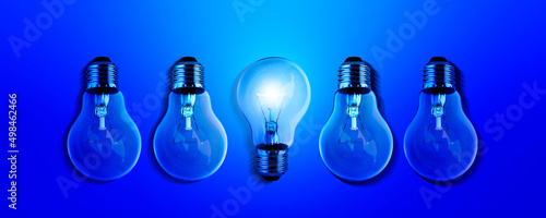 Light bulbs illuminate a row of dim lighting ideas for creativity, innovation and solutions