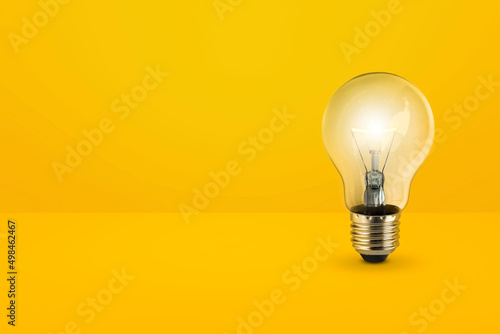 Valokuvatapetti light bulbs on bright yellow background in pastel colors simple concept bright i
