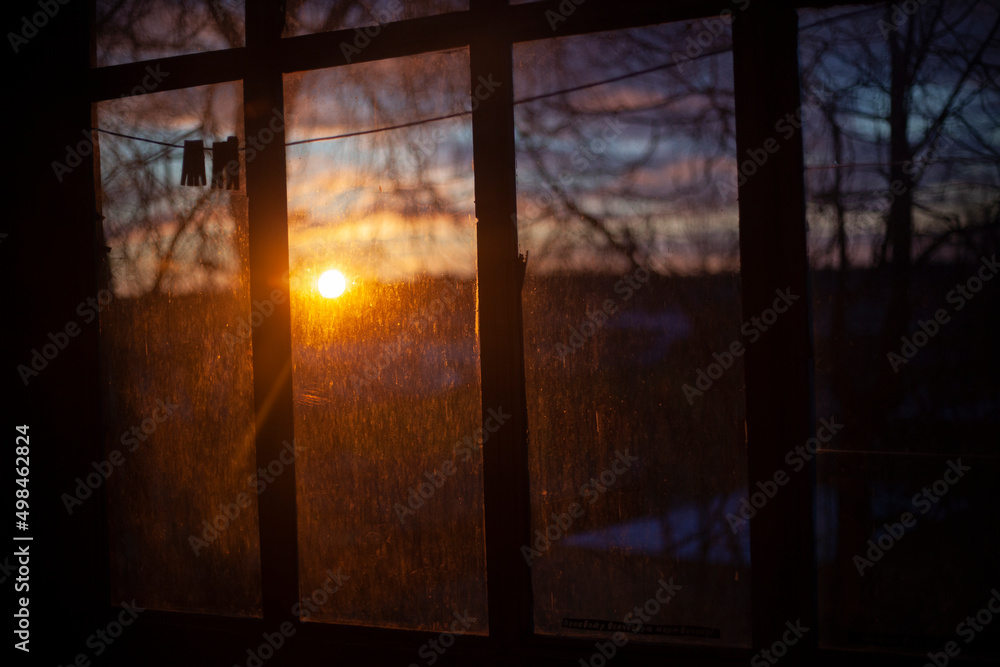 Dawn through the window. The sun rises behind the glass. Morning in autumn. T Dawn through the window. The sun rises behind the glass. Morning in autumn. T
