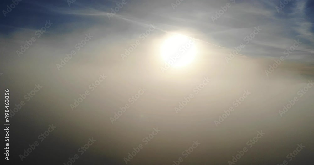 Aerial shot of thick cloud passing over the sun with a blue sky Aerial shot of thick cloud passing over the sun with a blue sky