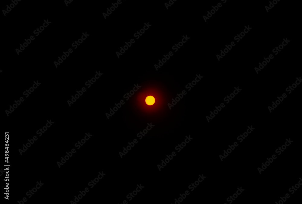 The sun photographed in its natural beauty through a red filter on a black background