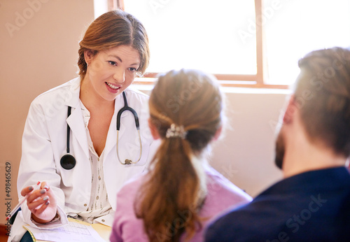 Shes invested in the health of all her patients. Shot of a pediatrician consulting with a man and his young daughter in her office.