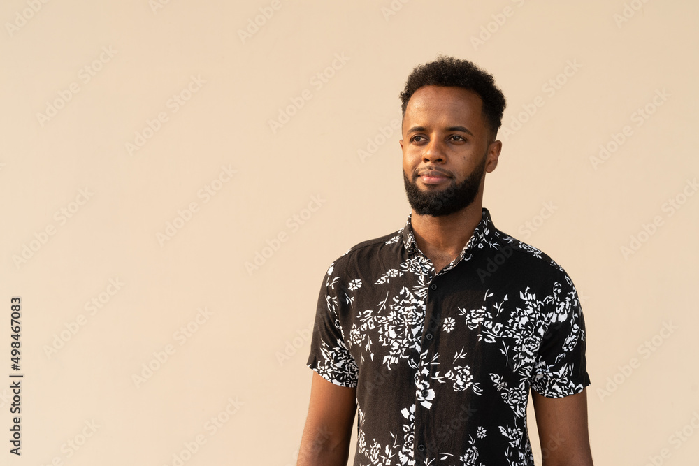 Obraz premium Portrait of handsome young African man against plain background
