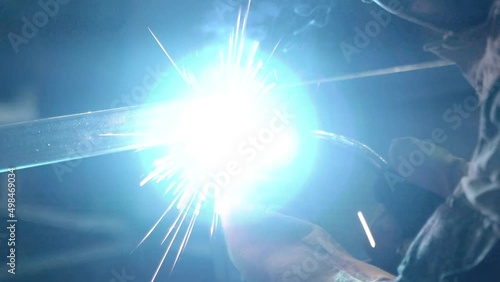A worker cooks metal on a welding machine in production. a worker with a welding machine to cook parts. Close up