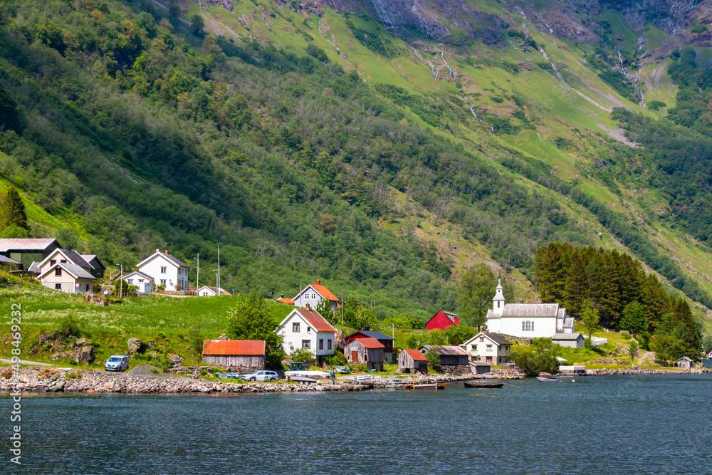 Traditional Norwegian small village with red wooden houses in Aurlandsfjord. Amazing beautiful view of the green mountains