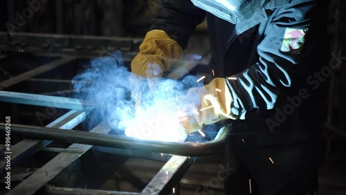 A worker cooks metal on a welding machine in production. a worker with a welding machine to cook parts. Close up