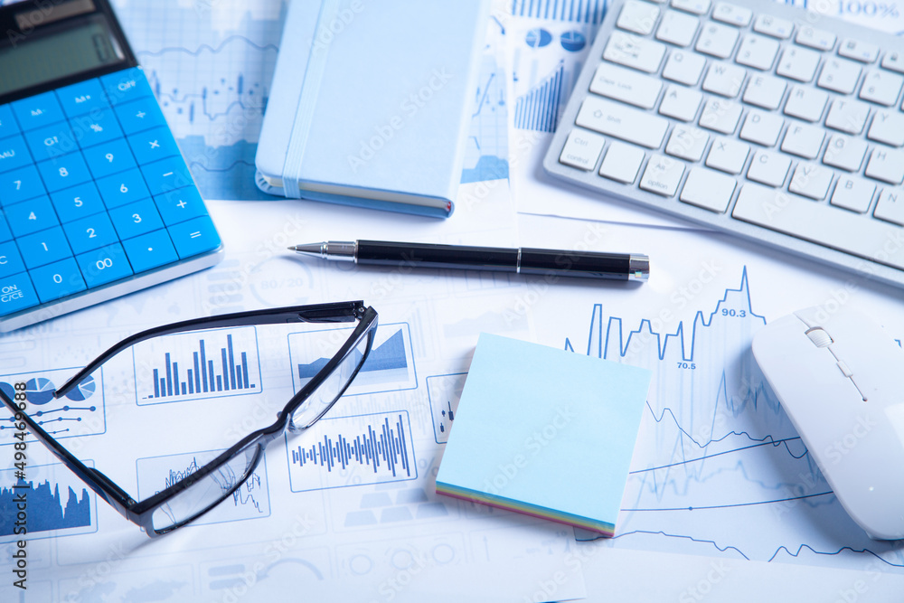 Calculator, pen, computer keyboard on financial graphs. Calculator, pen, computer keyboard on financial graphs.