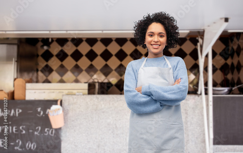 Fotografia work, job and people concept - happy smiling woman in apron over food truck on s