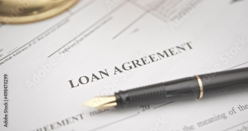 Business loan agreement or legal document concept : Fountain pen on a loan agreement paper form. Loan agreement is a contract between a borrower and a lender, a compilation of various mutual promises. photo