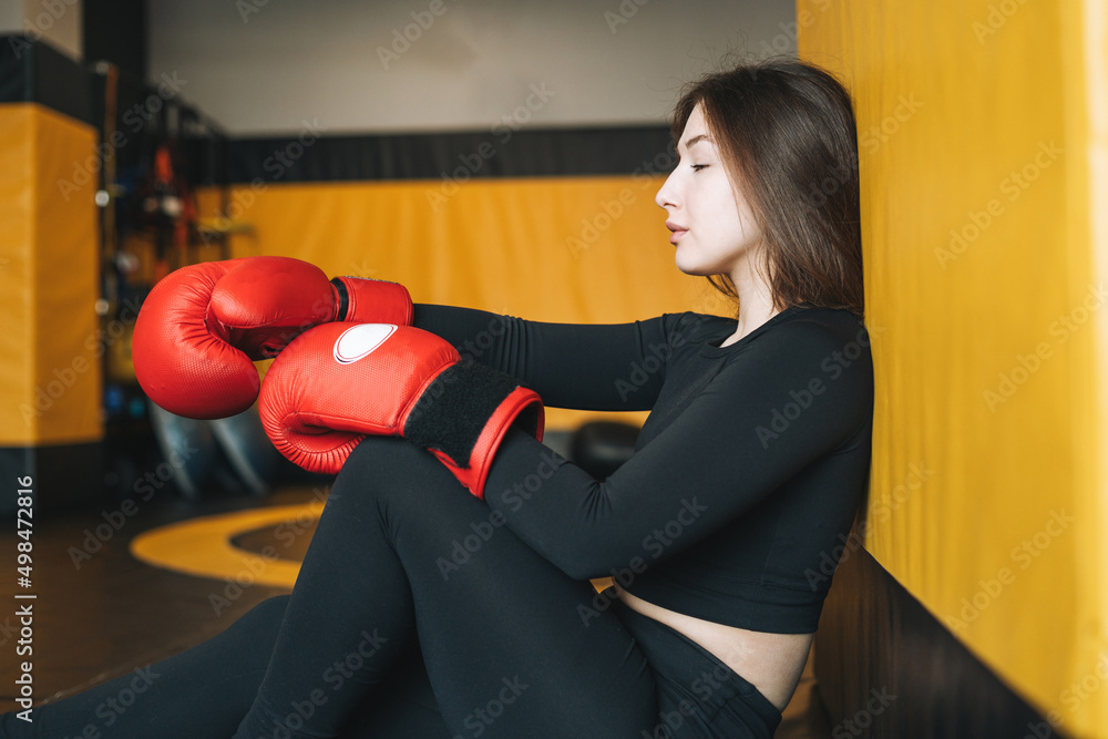 Young brunette woman in black wear engaged boxing training in fitness club gym
