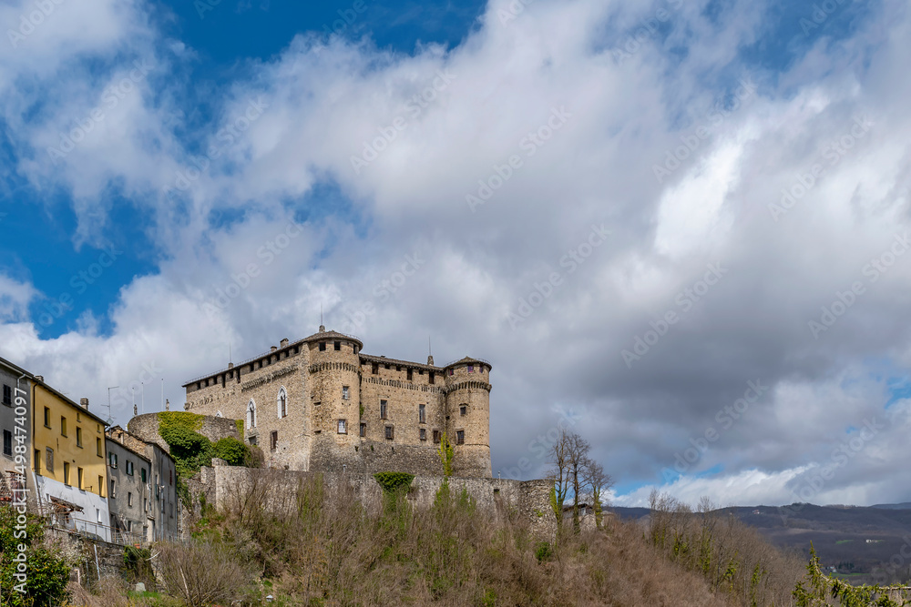 The ancient castle of Compiano, Parma, Italy, under a beautiful sky with white clouds