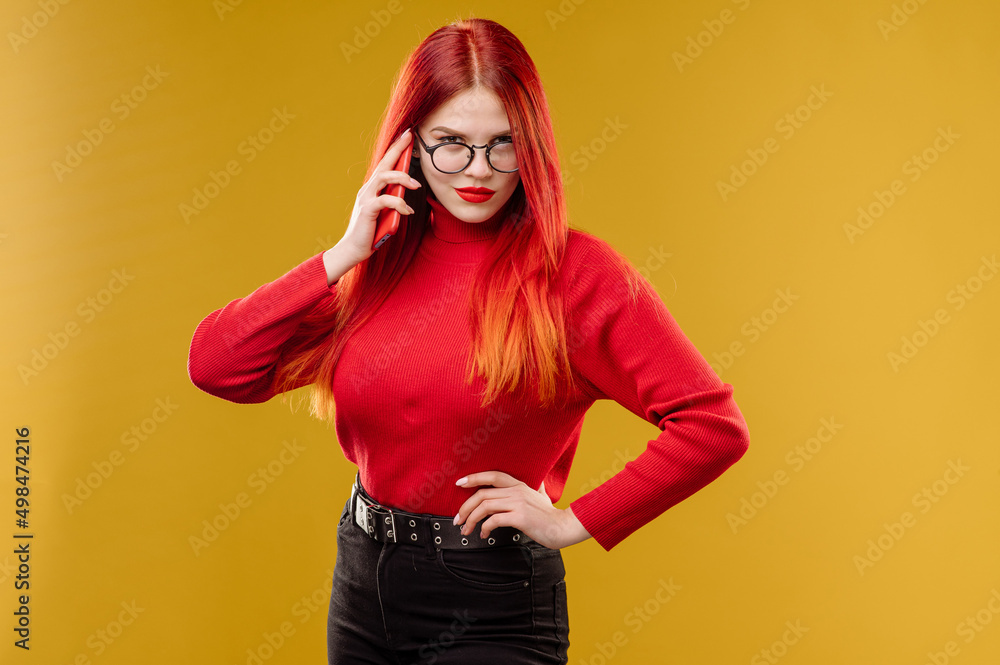 Glamour woman wearing glasses using smartphone on yellow background Glamour woman wearing glasses using smartphone on yellow background