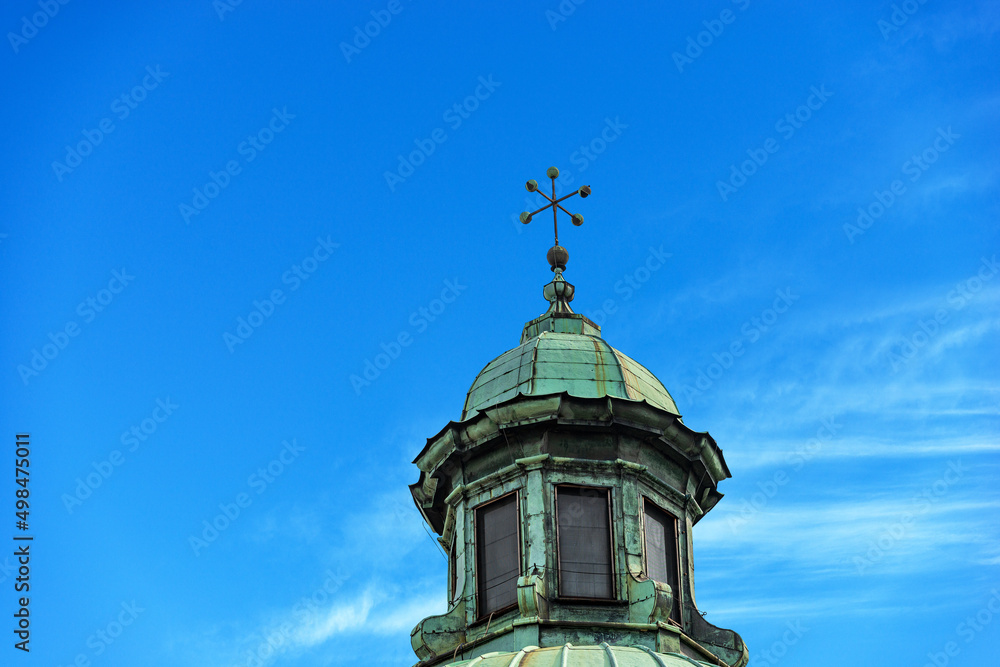 Close-up of the Treviso Cathedral (Duomo o Cattedrale di San Pietro Apostolo - Saint Peter the Apostle), VI-XIX century, Veneto, Italy, Europe. Dome with lantern and cross on blue sky with clouds.