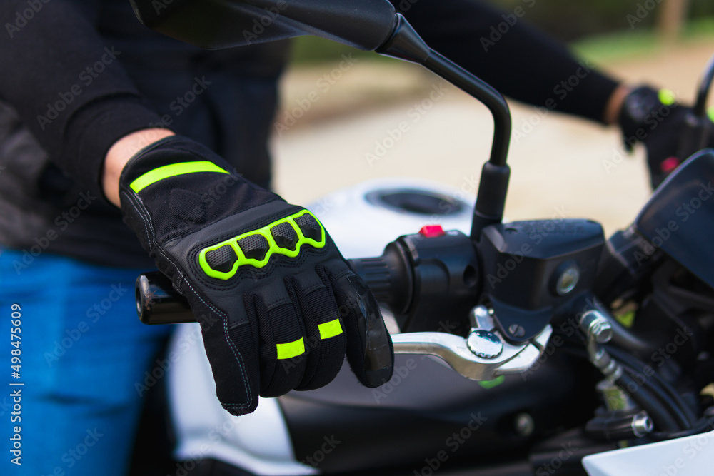 close-up view of a glove-covered man's hand on the steering wheel of a motorcycle who is about to continue his way close-up view of a glove-covered man's hand on the steering wheel of a motorcycle who is about to continue his way