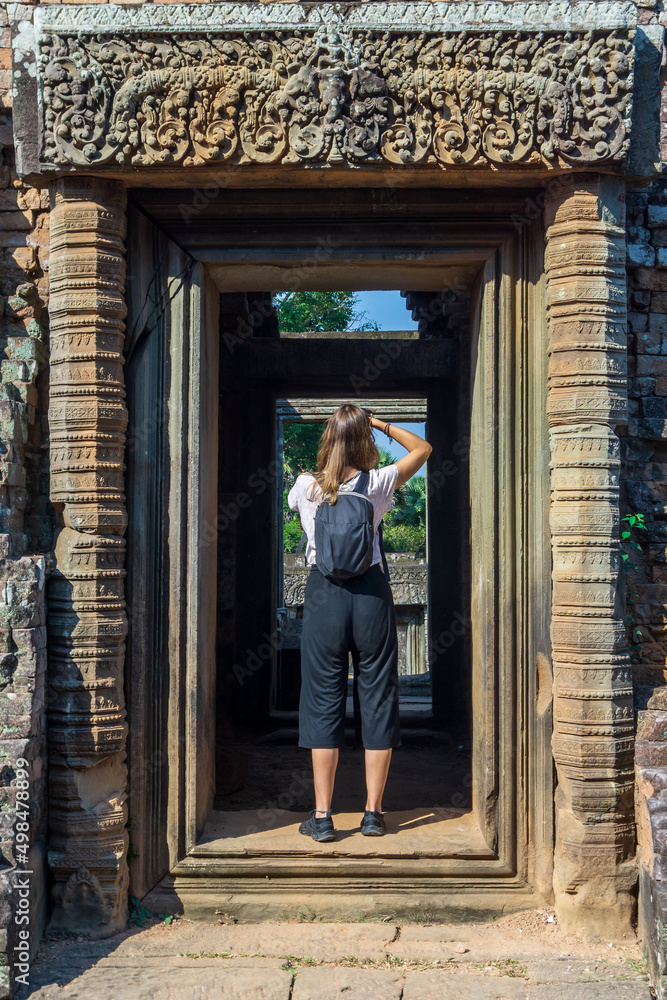 Young female tourist taking a picture  in Angkor Wat, Siem Reap, Cambodia.