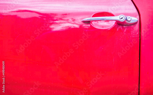 Classic sixties car's shiny nickel handle and red painted door, space for your text or logo.