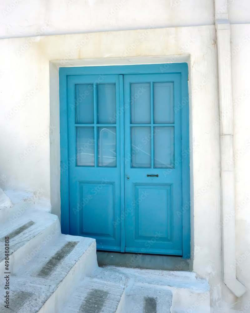 Blue entrance door by the alley stairs in Chora, capital of Andros island, Greece.
