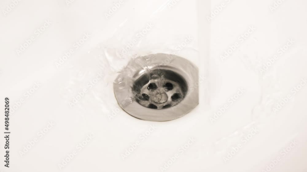 The water drains into the sink in the bathroom. 4K footage The water drains into the sink in the bathroom. 4K footage