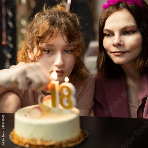 Happy friends birthday party with candle celebration cakes. Teens Grils celebrating birthday party. photo