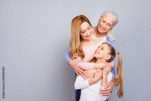 Photo of three cheerful friendly people embrace enjoy each other isolated on grey color background