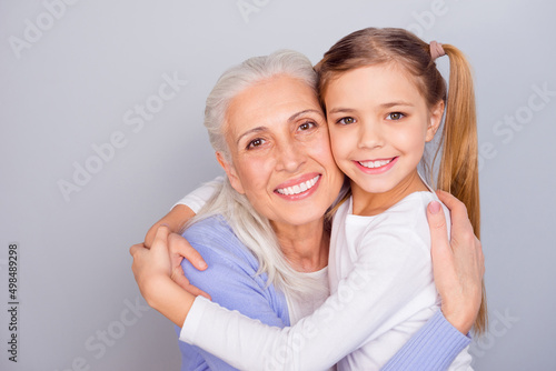Photo of two friendly lovely people cuddle toothy smile look camera isolated on grey color background
