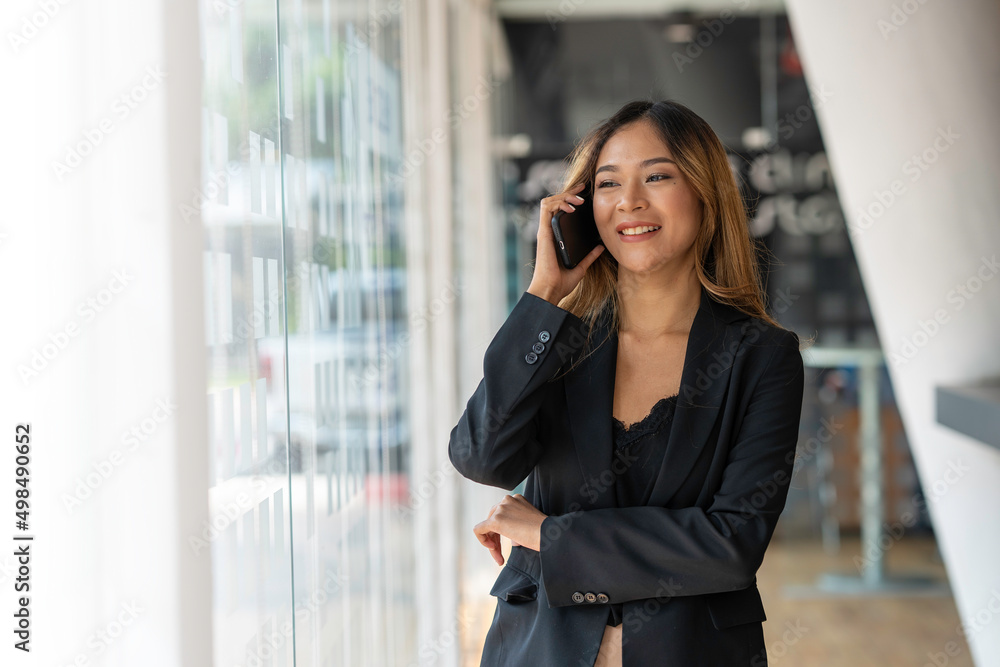Portrait of a smiling asian businesswoman talking on mobile phone and looking away Portrait of a smiling asian businesswoman talking on mobile phone and looking away
