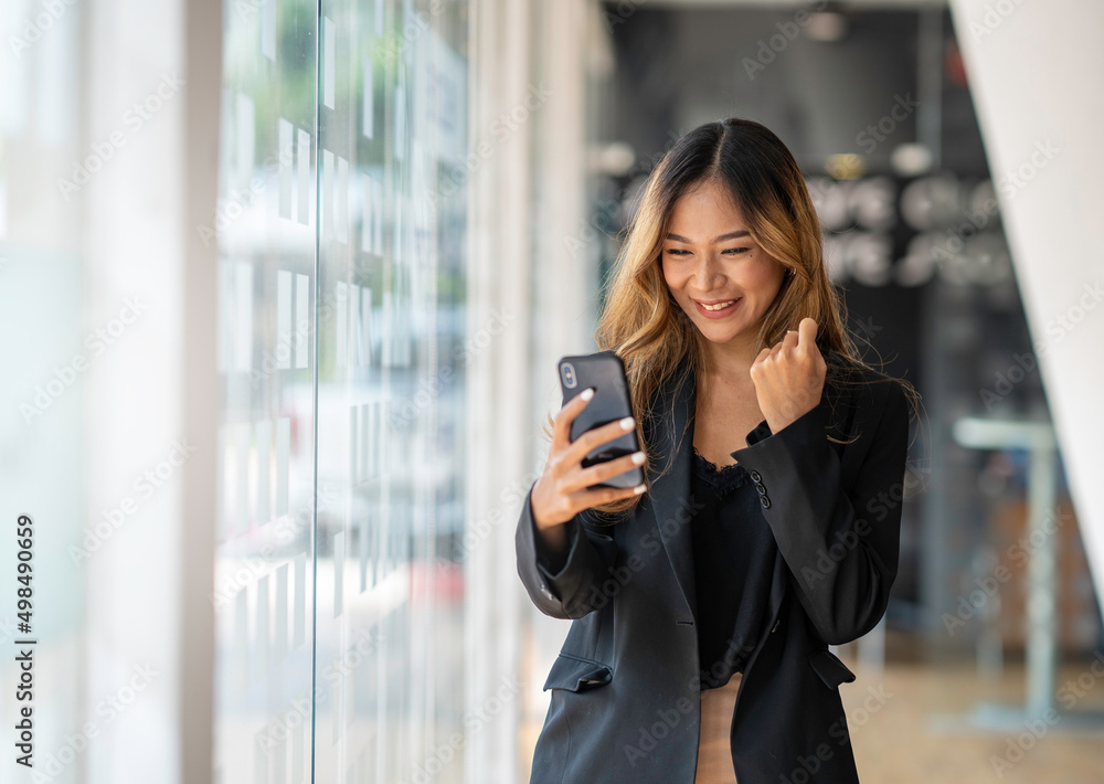 Asian businesswoman using smartphone for video call working at office desk