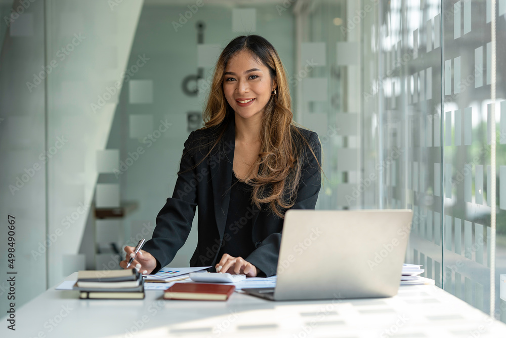 Asian businesswoman sitting working on laptop in office. tax, accounting, financial concept Asian businesswoman sitting working on laptop in office. tax, accounting, financial concept