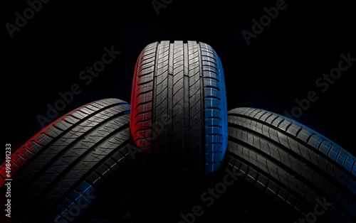 New car tires. Group of road wheels on dark background. Summer Tires with asymmetric tread design. Driving car concept.