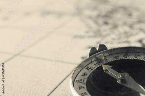 Magnetic old compass on world vintage  map.Travel, geography, navigation, tourism and exploration concept background.Macro shot, shallow focus.