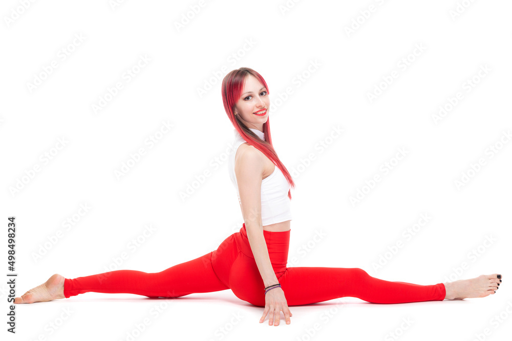 Fototapeta premium A beautiful, athletic, slim, smiling and cheerful woman in a white top and red sweatpants performs stretching and Pilates elements. Lifestyle concept with sports and gym, healthy lifestyle. Isolated