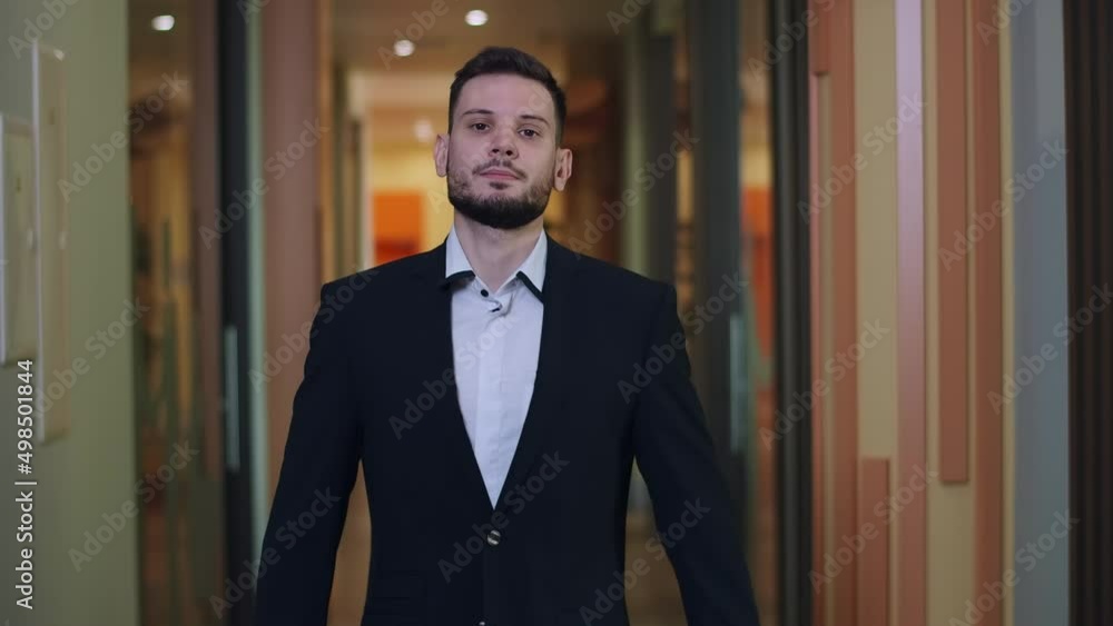 Successful young businessman buttoning formal suit and looking at camera. Portrait of confident Caucasian handsome man posing in office corridor. Lifestyle and confidence concept Successful young businessman buttoning formal suit and looking at camera. Portrait of confident Caucasian handsome man posing in office corridor. Lifestyle and confidence concept