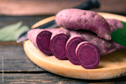 Raw purple sweet potato on cutting wooden board photo